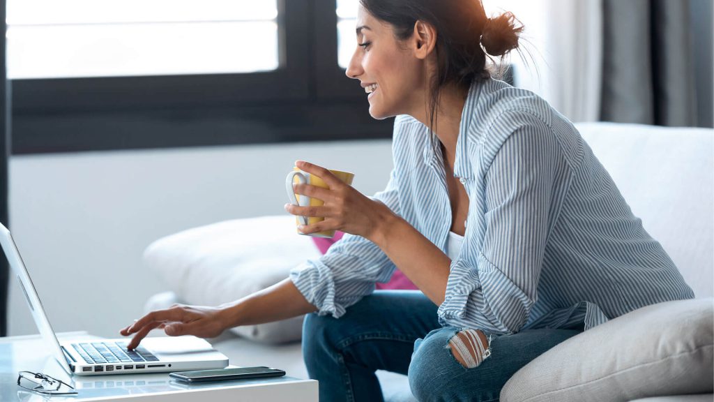 Smart business women, sat with hot drink on laptop
